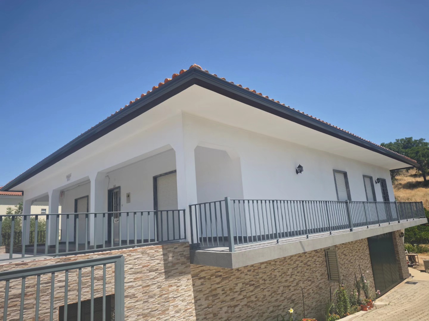 Caleiras em moradia com varanda e pedra